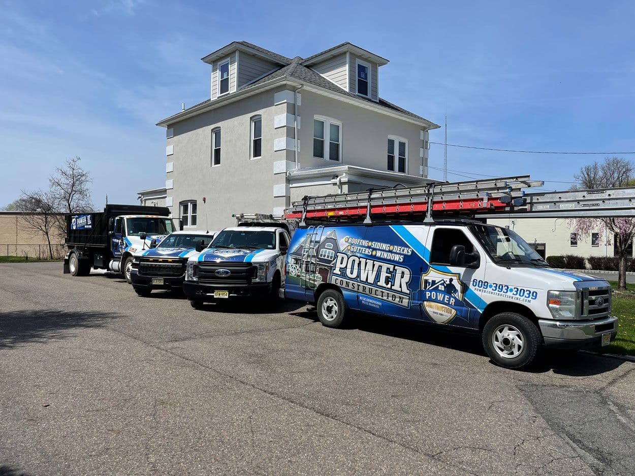 The Power Construction fleet of vans and trucks parked outside a job