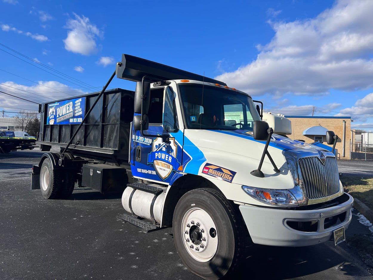 A Power Construction dump truck in the company's blue and white livery
